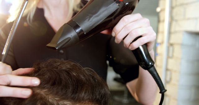 Hairdresser blow drying client's hair in salon - Download Free Stock Images Pikwizard.com