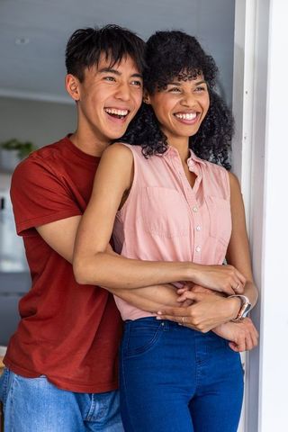 Young couple embracing in doorway with smartwatch health data overlay