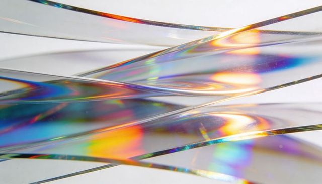 Iridescent holographic film ribbons refracting rainbow light abstract background