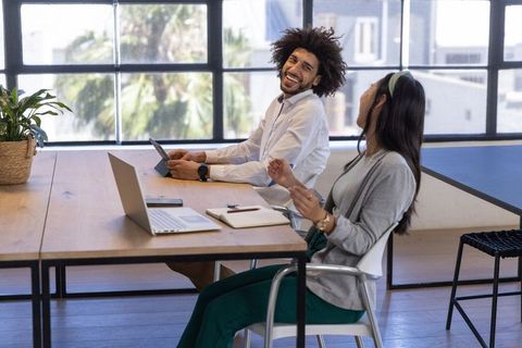 Diverse Coworkers Engaging in Discussion at Modern Office Desk