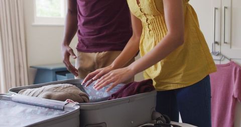 Couple preparing suitcase for travel and adventure