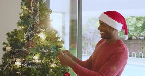 Festive Man Delighting in Christmas Tree Decoration