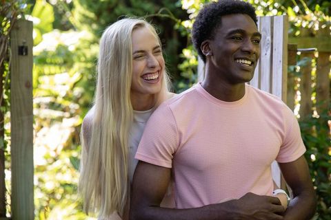 Happy Couple Embracing in Lush Garden Backdrop