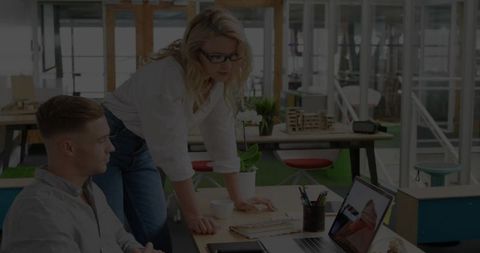 Colleagues Collaborating on Laptop in Contemporary Office