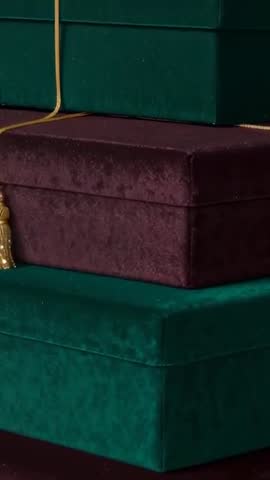 Vertical Video Revealing Stacked Velvet Gift Boxes with Gold Cord and Tassel