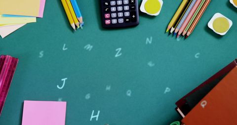 Colorful Stationery on Green Desk with Floating Alphabets - Download Free Stock Images Pikwizard.com