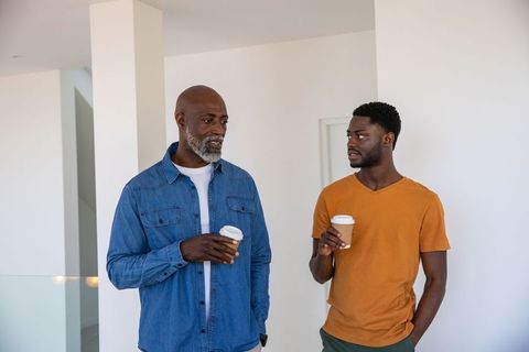 Father and Son Enjoying Coffee in Modern Home Hallway