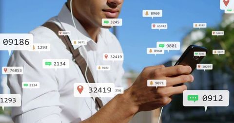 Young man checking black smartphone with earbuds as notification bubbles float over city street