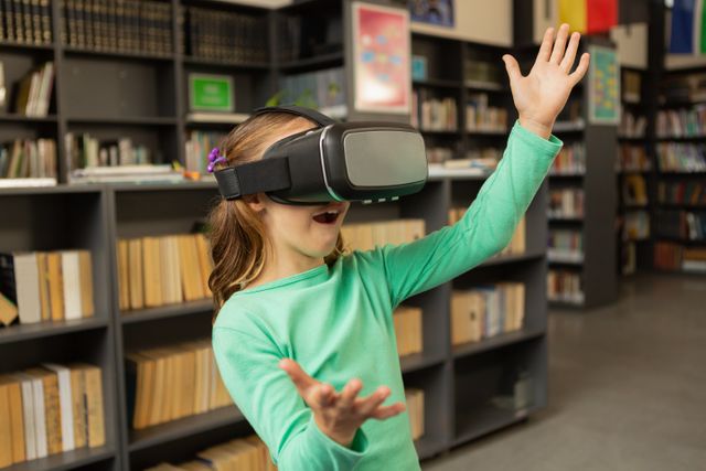 Front view of Caucasian schoolgirl using virtual reality headset in library at elementary school