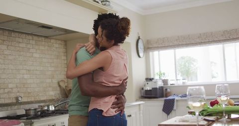 Happy Couple Embracing in Kitchen During Cooking at Home