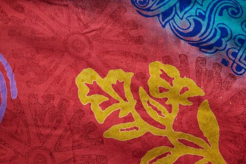 Featuring handcrafted batik pattern with bold yellow foliage on vibrant red blue fabric