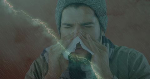 Sick man sneezing with storm background