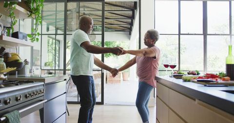 Senior African American Couple Dancing Joyfully in Modern Kitchen