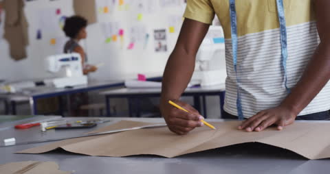 Fashion Student Designing Apparel Pattern in Studio with Pencils and Paper