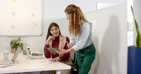 Diverse female colleagues collaborating in office increases team productivity