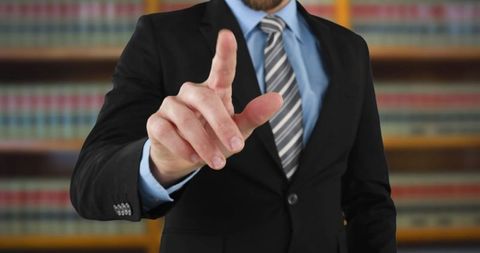 Businessman pointing in office library showing leadership