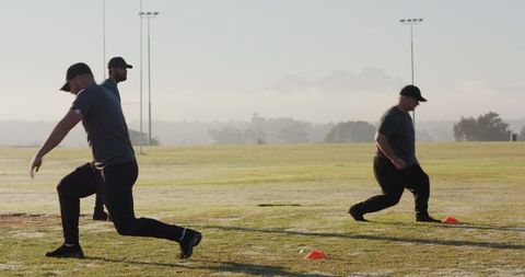 Early Morning Team Training with Cones, Players Performing Agility Drills on Grass