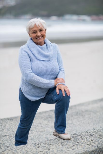 Portrait of senior woman standing on the steps near beach