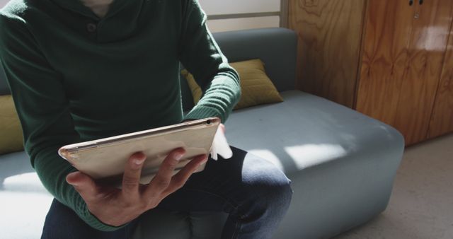 Person Wearing Green Sweater Using Tablet on Sofa Indoors - Download Free Stock Images Pikwizard.com