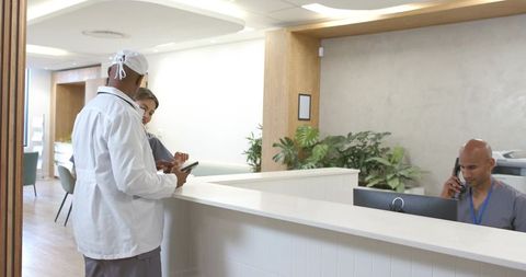 African american medical team collaborating at clinic reception desk