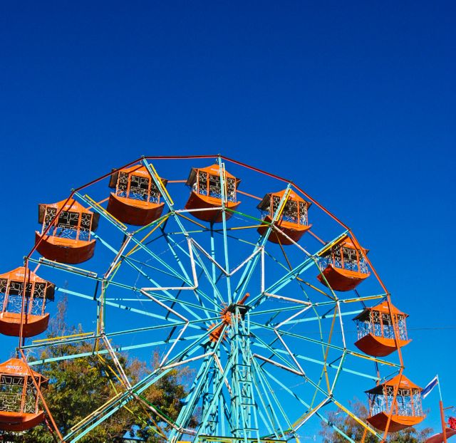 Colorful Ferris Wheel Against Clear Blue Sky at Amusement Park - Download Free Stock Photos Pikwizard.com