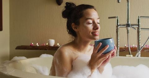 Serene woman indulging in relaxing bath with coffee