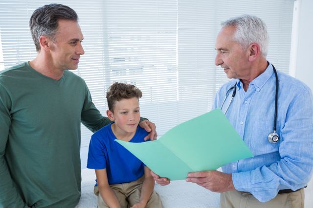 Doctor Discussing Medical Report with Father and Son in Clinic - Download Free Stock Photos Pikwizard.com