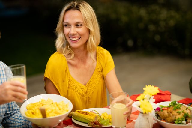 Caucasian woman enjoying their time at home together, sitting by a table, talking, smiling and interacting.