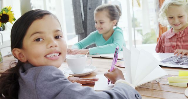 Smiling Young Children Drawing and Writing Together at Table - Download Free Stock Images Pikwizard.com