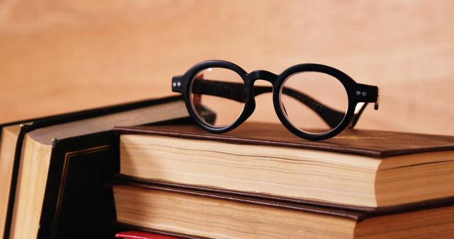 Round Eyeglasses Resting on Stack of Vintage Books on Wooden Desk - Download Free Stock Images Pikwizard.com
