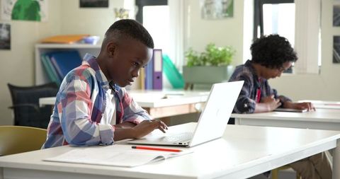 Focused Diverse Children Studying and Collaborating in Classroom