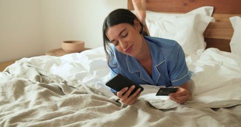 Woman Online Shopping in Cozy Bedroom with Credit Card