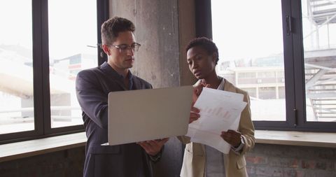 Business colleagues reviewing data in modern cafe setting