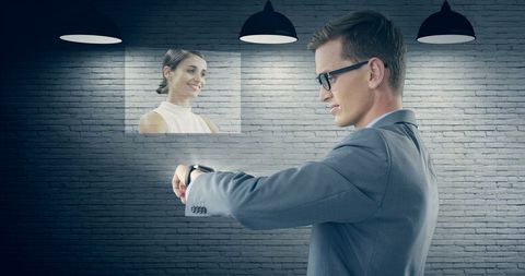 Businessman using smartwatch with woman's image projection inside