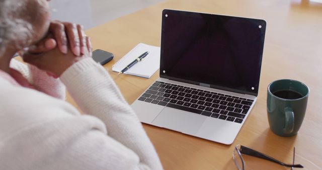 Senior Person Contemplating at Desk with Laptop and Coffee - Download Free Stock Images Pikwizard.com