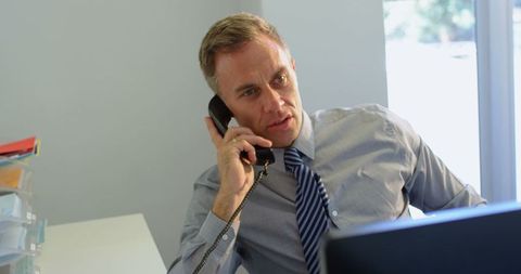 Focused Caucasian Businessman Discussing on Office Phone Call