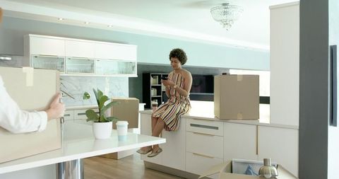 Diverse couple enjoying new kitchen amid moving process