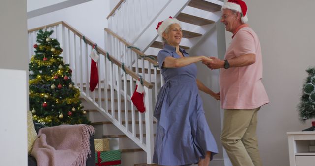 Happy caucasian senior couple wearing santa hats and dancing at christmas time - Download Free Stock Photos Pikwizard.com