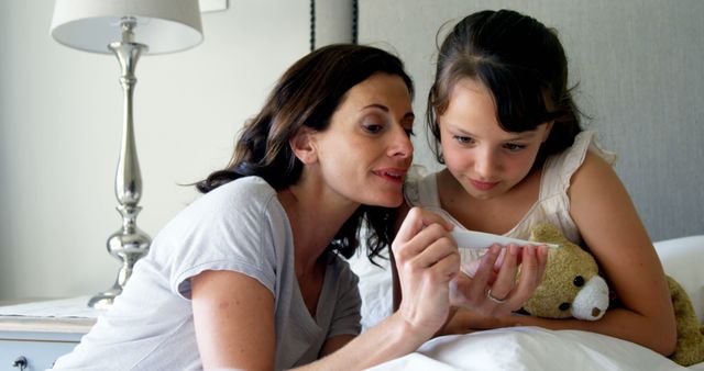 Mother and daughter bonding while using tablet in cozy bedroom - Download Free Stock Images Pikwizard.com