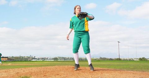 Female softball player on mound bright day team spirit