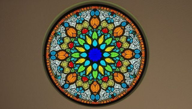 Colorful stained glass mandala rose window with geometric floral design