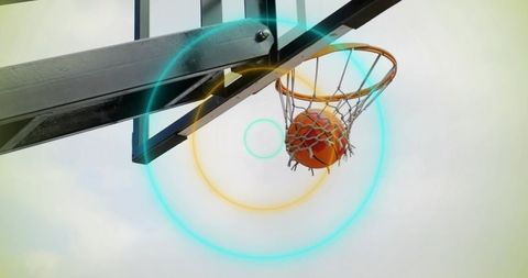 Basketball swoosh through hoop on outdoor court