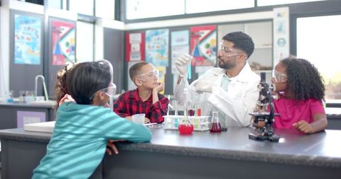Teacher demonstrating science experiment to diverse group of students