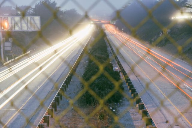 Light Trails of Traffic on Highway Through Chain Link Fence at Night - Download Free Stock Images Pikwizard.com