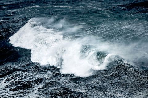 Powerful stormy ocean waves crashing with spray and foam aerial view dramatic seascape