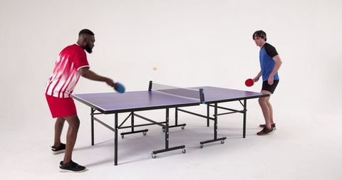Diverse Male Friends Competing in Table Tennis Match