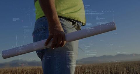 Engineer with Blueprint Discussing Plans in Vast Harvested Field