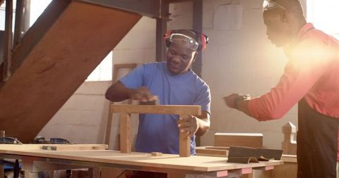 Senior Craftsmen Collaborating on Woodworking Project in Sunlit Workshop