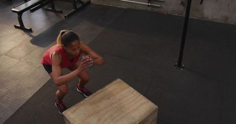 Female Athlete Performing Box Jump at Fitness Gym