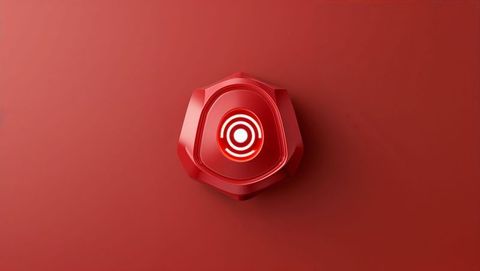Red hexagonal device with illuminated target on minimalistic surface, red alert concept